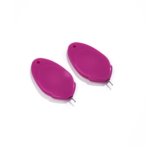 Macro view of two purple acrylic needle threaders with metal wire hooks for DIY sewing