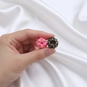 Detailed close-up of handmade gold silk woven peach blossom knot beads for DIY jewelry