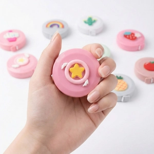 Close-up of portable mini soft tape measure with cute silicone 3D cartoon icons
