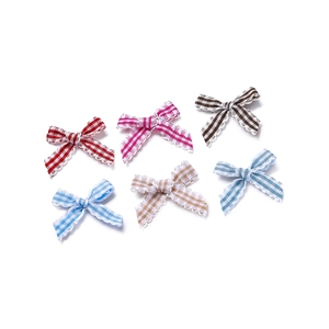 Detail view of colorful plaid bows with wavy edges for DIY crafts and hair accessories