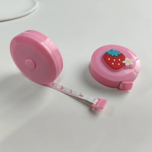 Macro detail of portable pink cartoon tape measure with strawberry decor and scale