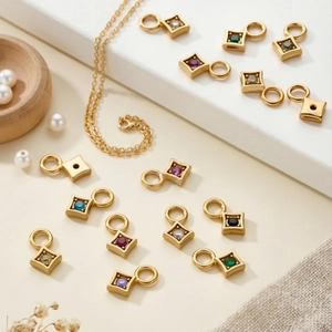 Detailed view of gold plated rhombus pendants with colorful zircon stones on jewelry stand