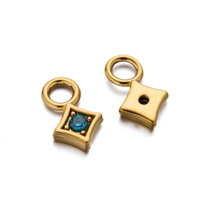 Detailed view of gold-plated geometric pendants with a blue zircon inlay and polished finish
