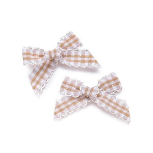 Close-up of light brown gingham bows with white scalloped lace edges for DIY crafts