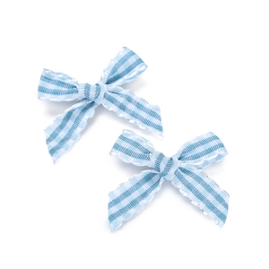 Close-up of two blue and white striped fabric bows with scalloped edges for DIY hair accessories