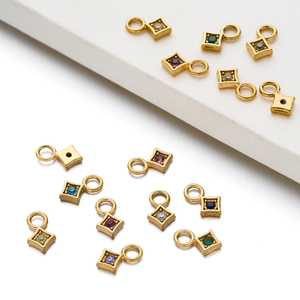 Macro detail of gold plated stainless steel square charms with colorful zircon stones