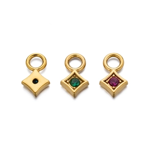 Macro shot of rhombus gold-plated charms with blue, green, and red zircons for DIY jewelry