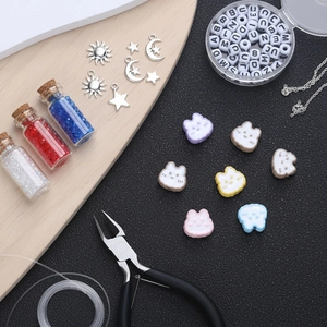 Macro shot of colorful resin bunny beads, letter beads, metal charms and DIY jewelry tools