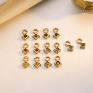 Macro view of 14 gold plated stainless steel diamond shaped pendants with colorful gemstones