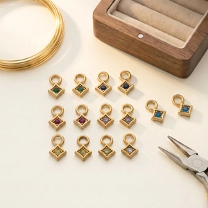 Macro shot of 14 gold-plated rhombus pendants with colorful gems for DIY jewelry making