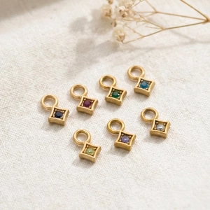 Macro shot of 7 colorful square gemstone pendants with gold-plated stainless steel borders
