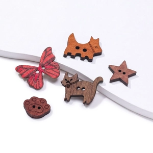 Detailansicht von Holzknöpfen mit Motiven von Katze, Hund, Schmetterling, Stern und Pfote