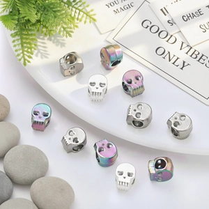 Detailed view of colorful and silver skull beads on a ceramic plate for DIY jewelry making
