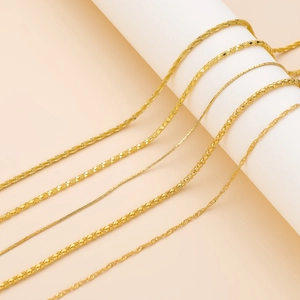 Detalle de varios colliers chapados en oro en diferentes estilos sobre un soporte