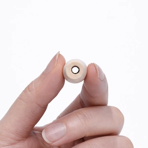 Macro view of a single natural 10mm round wooden bead with hole for DIY jewelry making