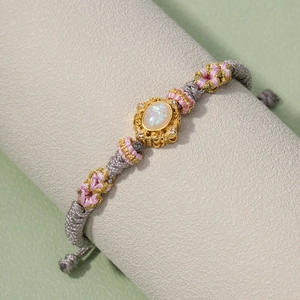 Handmade woven cord bracelet featuring an oval opal stone with gold bezel and gray rope
