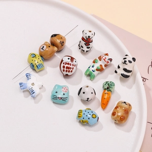 Close-up of hand-painted ceramic beads in animal shapes for DIY jewelry making