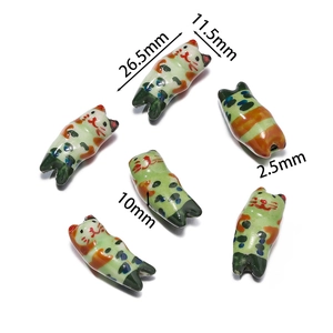 Detail view of hand-painted ceramic cat beads showing dimensions 26.5mm x 11.5mm