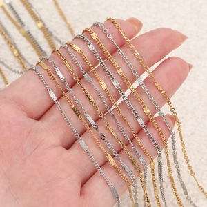 Detailed view of silver and gold stainless steel link chains held in hand for jewelry making
