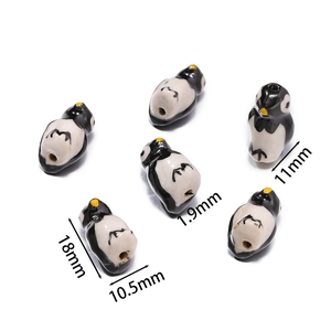 Detailed view of hand-painted ceramic penguin beads for DIY jewelry making with dimensions
