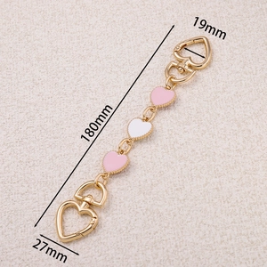 Détail de la chaîne d'extension de sac dorée 180mm avec breloques cœur roses et fermoirs