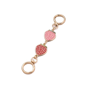 Détail du charme fraise avec émail rose et rouge et fermoirs à anneau à ressort dorés