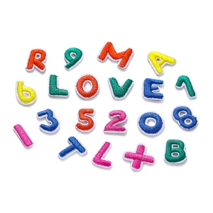 Primer plano de parches bordados coloridos con letras y bordes blancos para manualidades