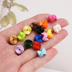 Colorful geometric acrylic stacking beads held in hand for DIY jewelry making