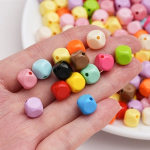 Hand holding 10mm macaron acrylic faceted cube beads for DIY jewelry and necklaces