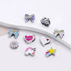 Dettaglio di ciondoli smaltati a cuore e panda per gioielli fai da te con strass brillanti