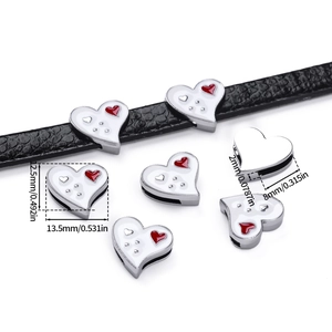 Macro shot of heart-shaped enamel charm on leather strap showing detailed dimensions
