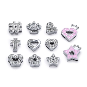 Macro detail of alloy charms with rhinestones and pink enamel for DIY bracelet making