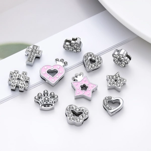 Macro view of rhinestone alloy heart, crown, and cross beads for DIY jewelry making