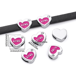 Macro detail of heart-shaped LOVE bead with pink enamel and crystal for DIY bracelets