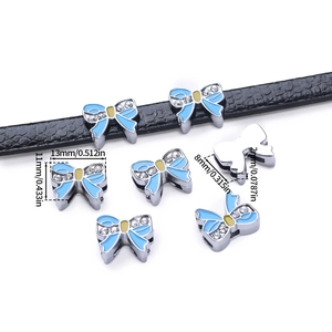 Detail view of 13mm silver alloy bow pendant with blue enamel and rhinestones