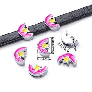 Dettaglio di ciondoli a luna in smalto rosa con stelle gialle per bracciali DIY