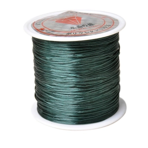Macro detail of 1mm dark green elastic crystal string on a spool for DIY jewelry making