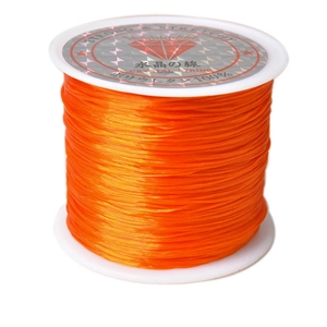 Close-up of orange elastic crystal string on a spool for DIY jewelry beadwork