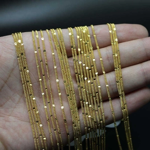 Macro detail of various gold-plated DIY necklace chains including classic flat and bead styles