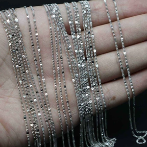 Macro view of various DIY silver-colored chain styles including box and wave chain links