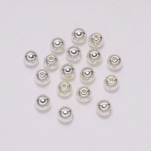 Macro-opname van zilveren ronde metalen kralen met gaten voor DIY sieraden maken
