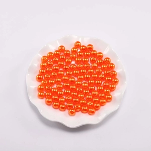 Macro-opname van levendige oranje ronde ABS-parels voor doe-het-zelf sieraden