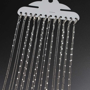 Detail von 12 versilberten Flachketten mit Karabinerverschlüssen auf Displaykarte