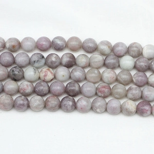 Macro shot of natural round stone beads in pale pink and grey for DIY jewelry making