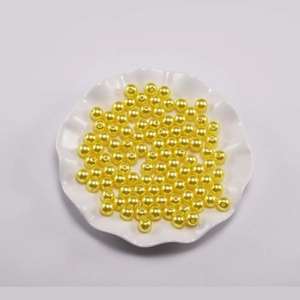 Detailopname van gele ABS-parelimitaties voor DIY-sieraden in een wit schaaltje