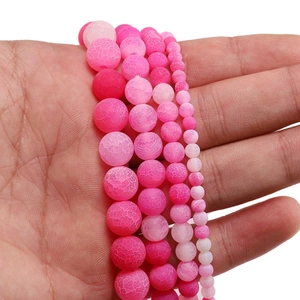 Macro detail of pink frosted weather agate beads showing various sizes and cracked texture