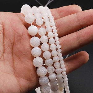 Macro detail of white weathered agate beads with ice-crack texture in four sizes