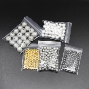 Dettaglio di perline distanziatrici tonde satinate in oro, argento e nero per gioielli DIY