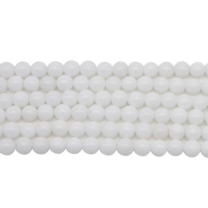 Macro shot of polished white synthetic stone round beads arranged in neat horizontal rows