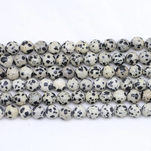 Detailed close-up of round Dalmatian Jasper beads with natural black spotted patterns